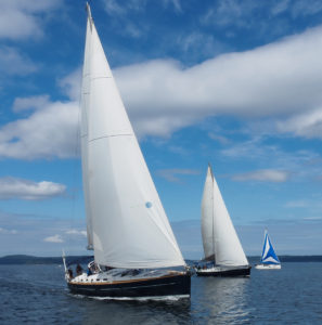 Three sailboats racing in a sailing regatta