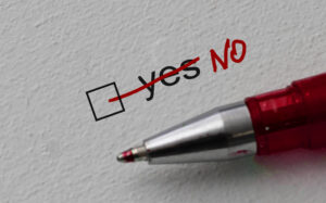 The word "yes" crossed out and replaced with "no" written on white paper with a red pen.