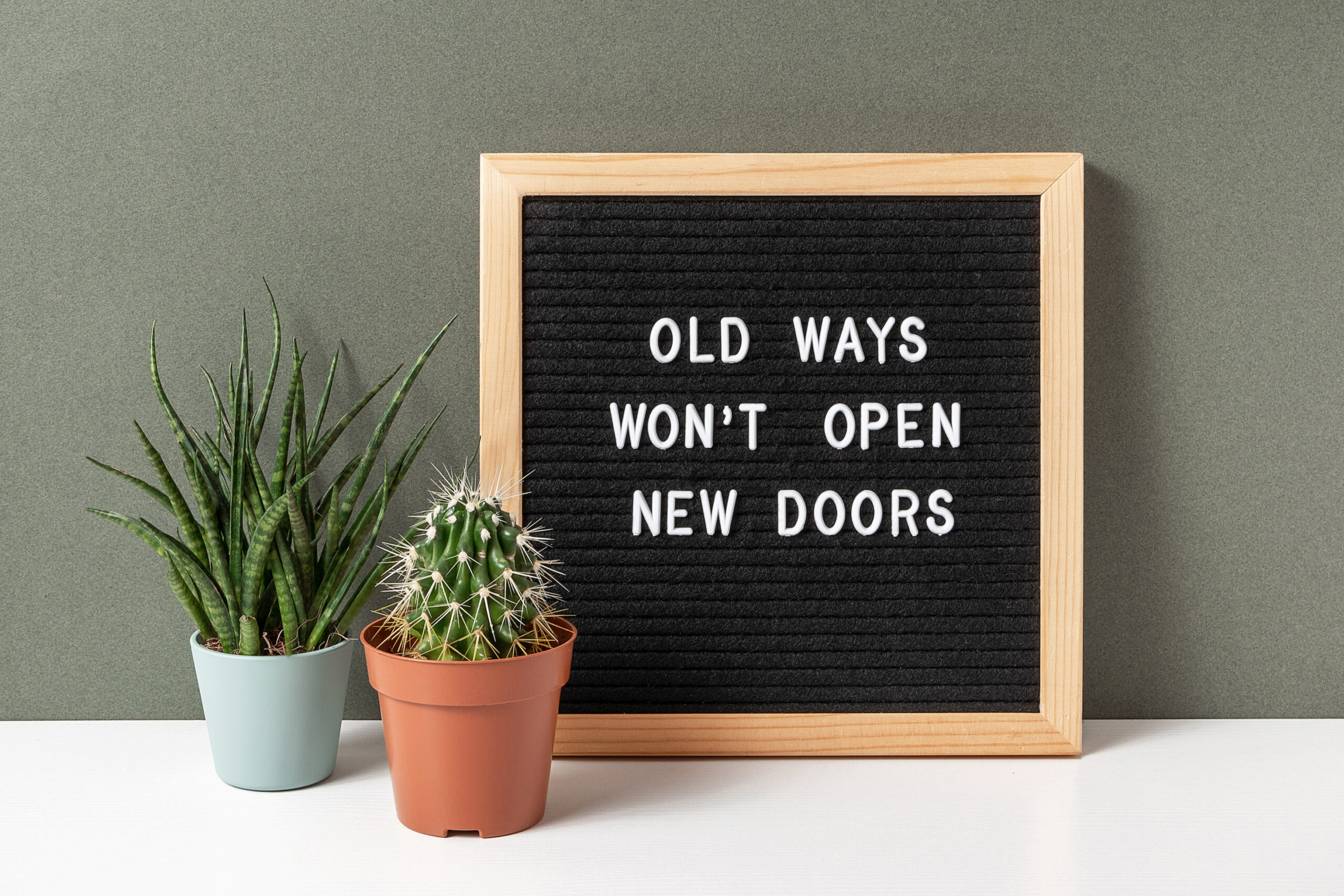 A letter board with the quote "Old Ways Won't Open New Doors."
