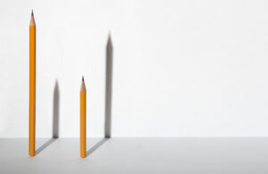 Two pencils of different lengths casting shadows of reversed lengths.