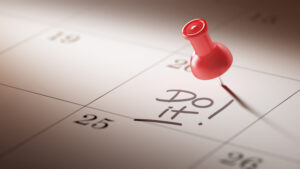 A red pushpin stuck in a calendar next to the words, "Do it!"