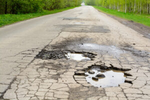 Potholes in an asphalt road, filled with water