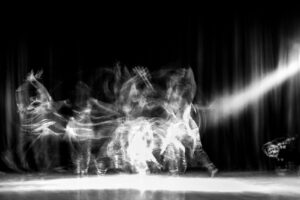 A dancer in a theater shot with a slow shutter speed in order to achieve motion blur.