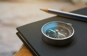 A compass sitting on top of a notebook