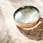 A magnifying glass sitting on an old nautical chart